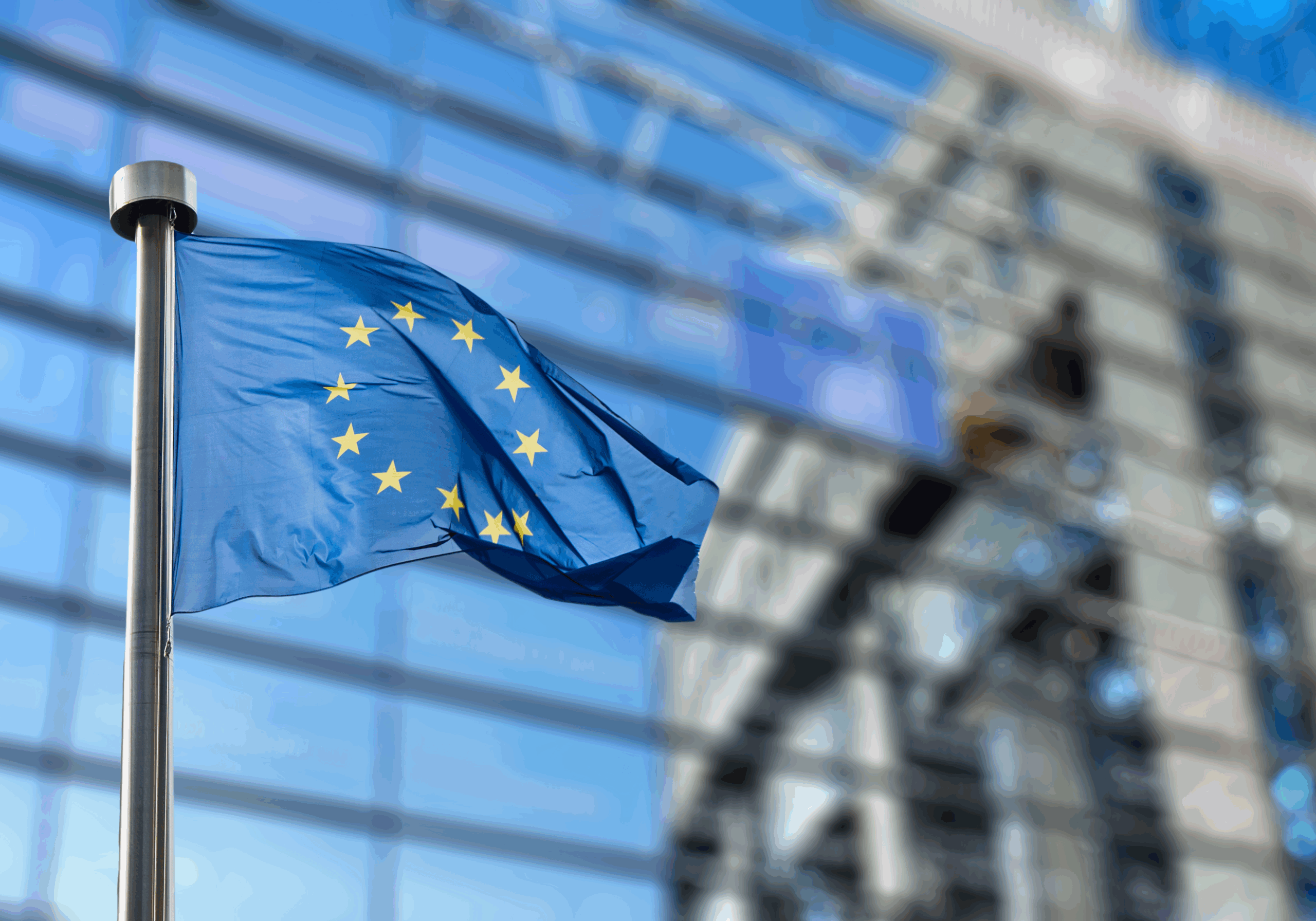 Wapperende vlag van de Europese Unie voor het gebouw van het Europees Parlement.