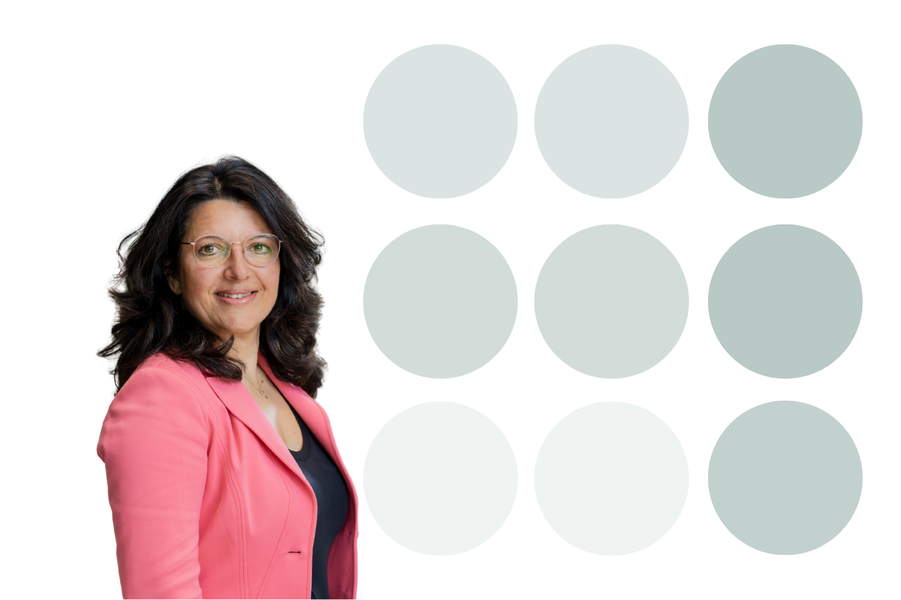 Vrouw met bril en roze colbert poseert voor een witte achtergrond met negen grijze cirkels.