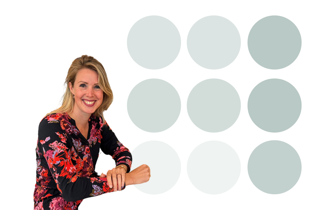 Vrouw met blond haar en bloemenblouse lacht voor een witte achtergrond met grijze cirkels.