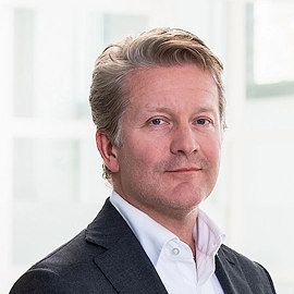 Portret van Martijn Rozemuller in een zakelijke omgeving.