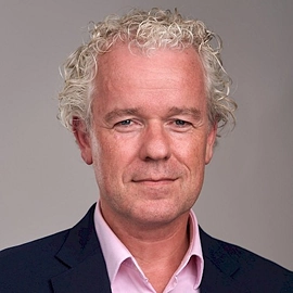 Portretfoto van Wilrik Jetten, bestuurslid van DUFAS, tegen een neutrale achtergrond.