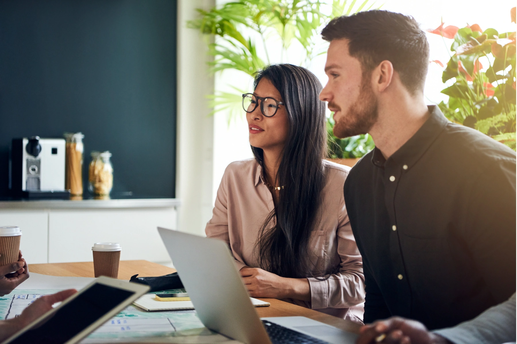 Twee jonge professionals in overleg tijdens een consultatie in een moderne kantoorruimte.